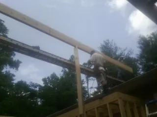 Carpenter setting a ridge beam over a new addition frame — Ice Dam Removal by Roofing Brothers in Edgefield