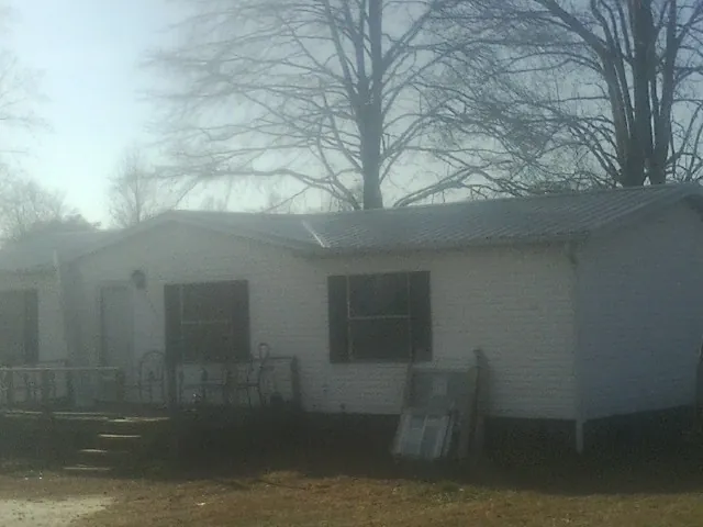 New metal roof on a white painted brick home on a foggy morning in Edgefield